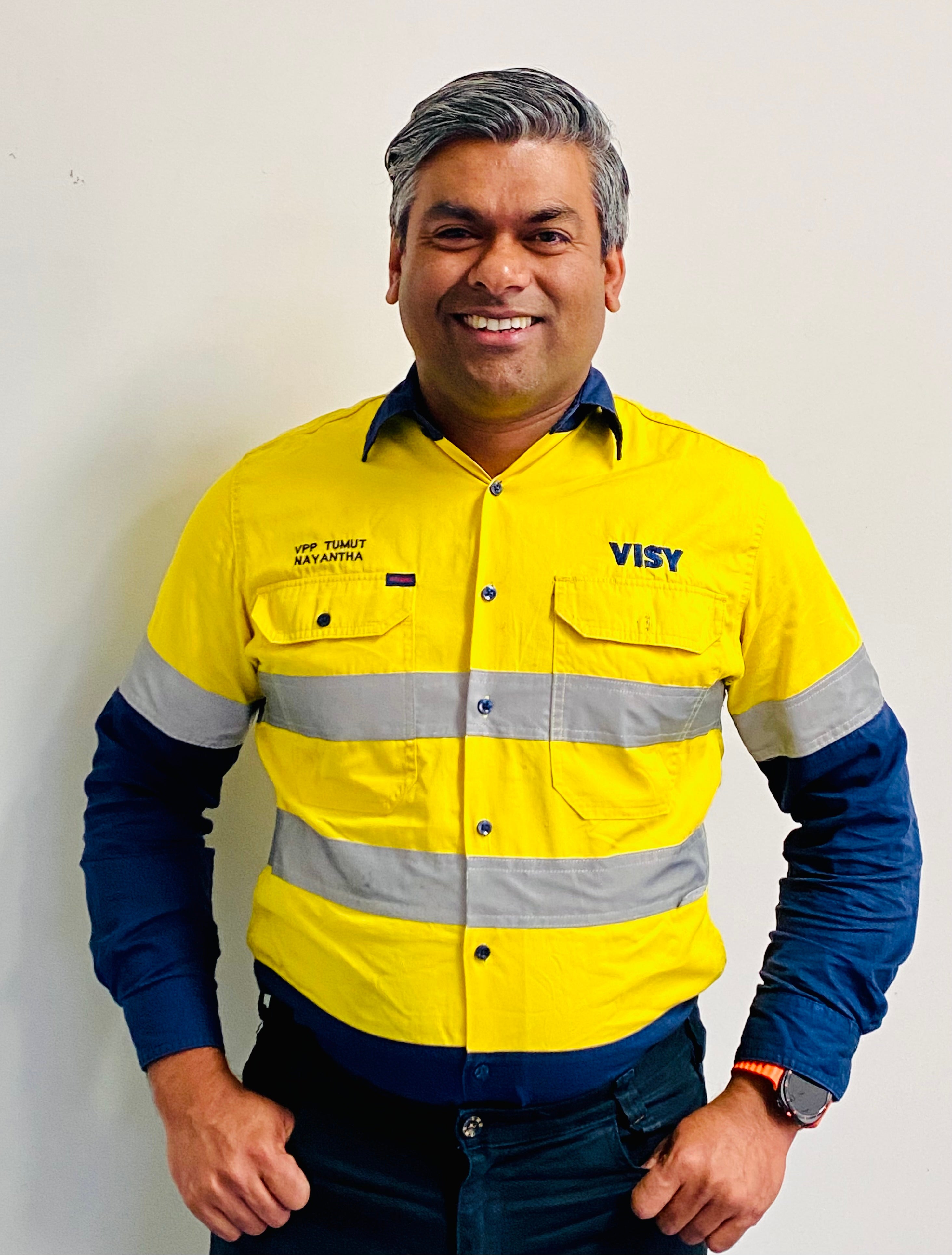 Man wearing yellow high-vis top smiles at the camera.