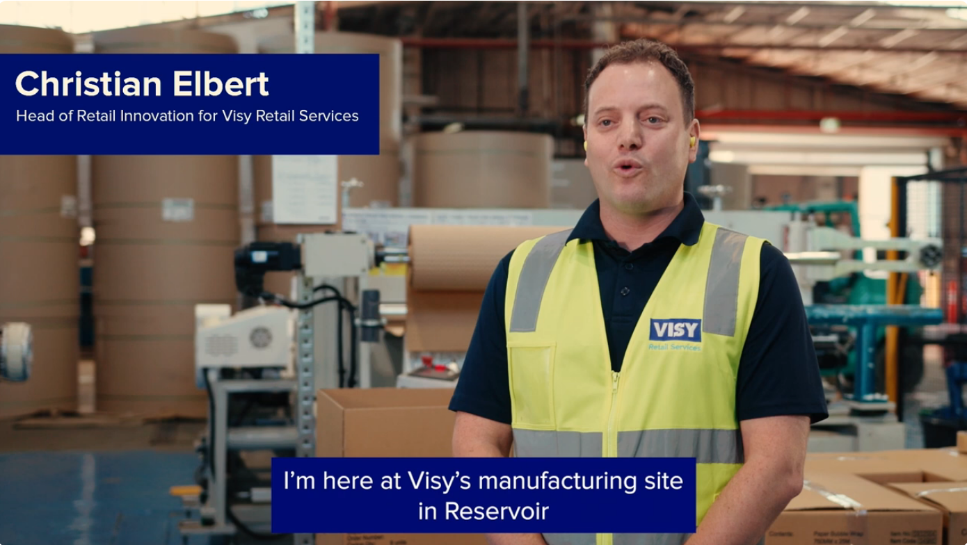 A man in a high vis vest talking to camera in a factory