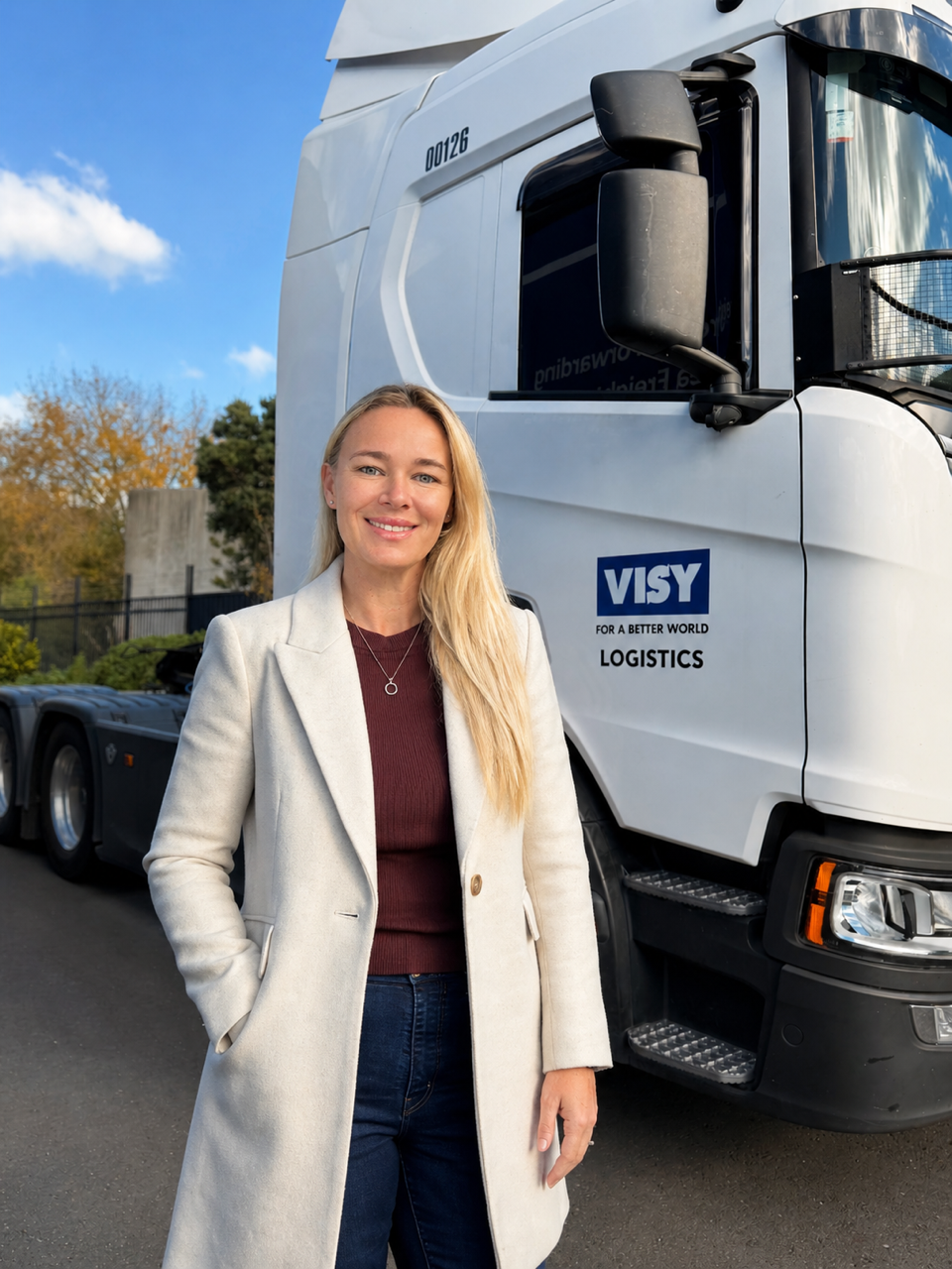 Suzette smiles at the camera, standing in front of a Visy Logistics truck.