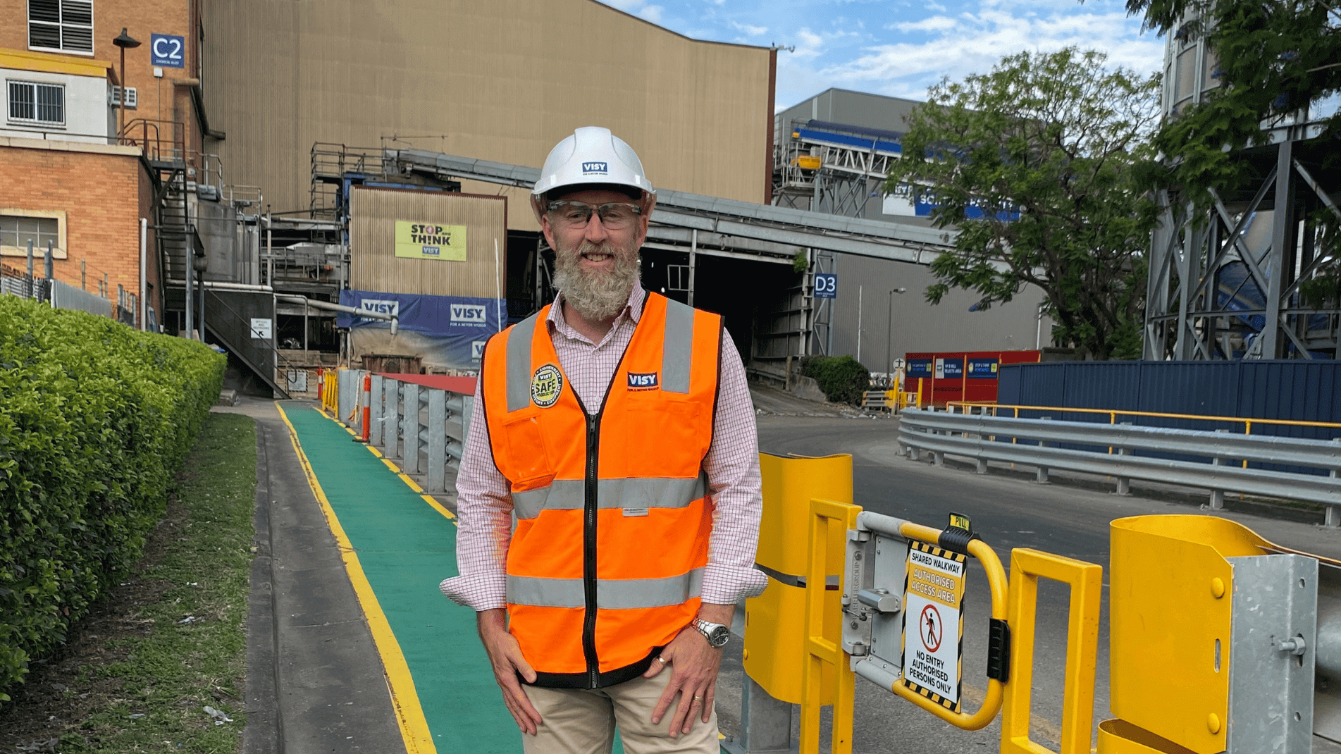 A man standing on a work site in a hi-vis vest
