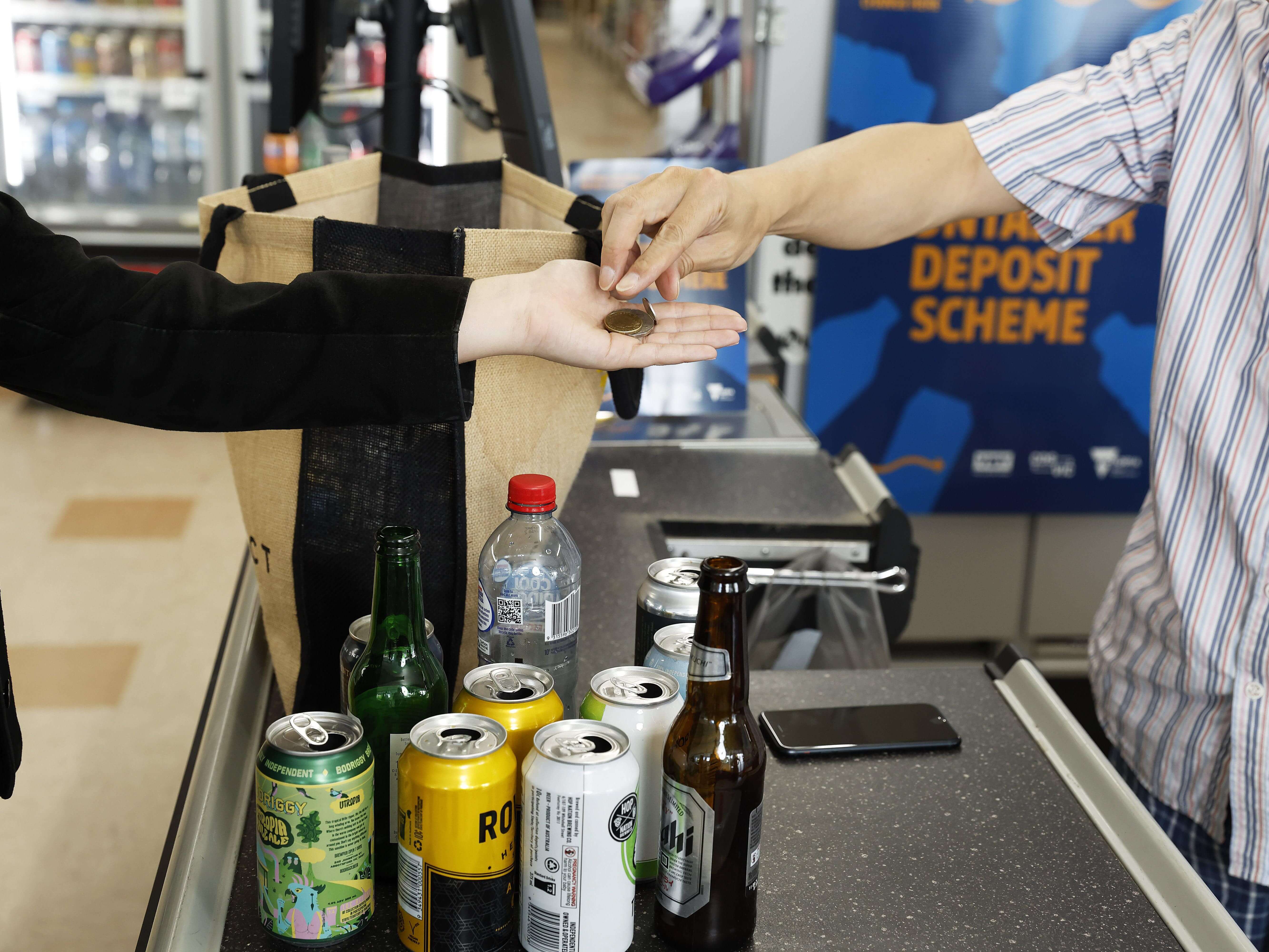 Two people exchanging coins for drink packaging