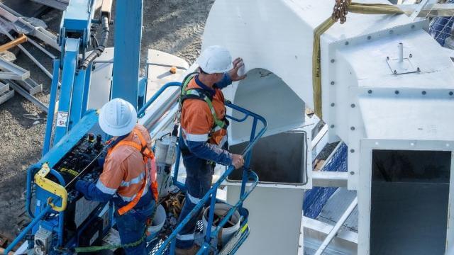 Two team members install frames for our new glass furnaces.
