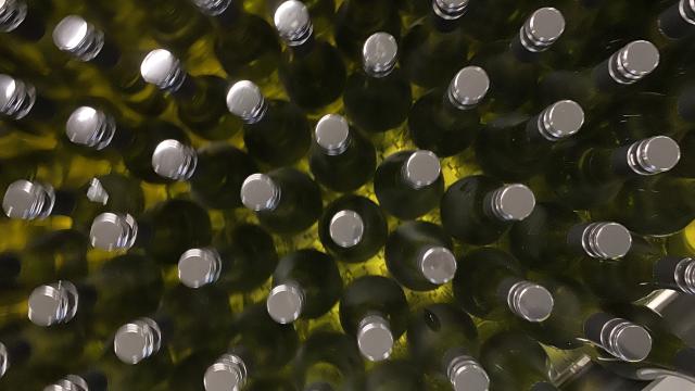 Birds-eye view of a large number of green glass wine bottles.
