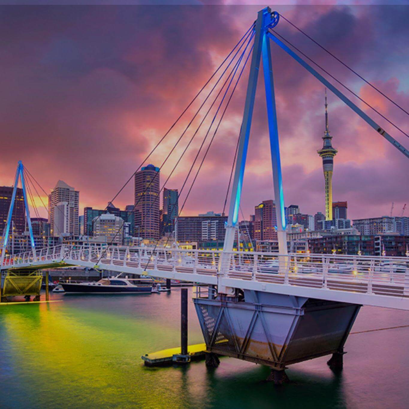 Bridge at sunset with city skyline in the background
