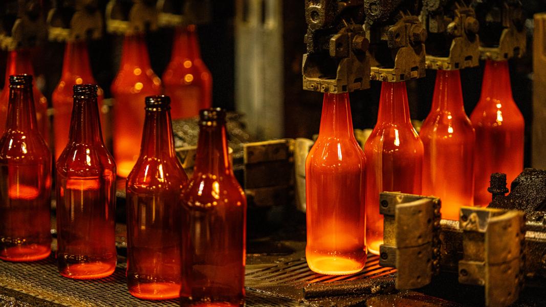 Red hot glass bottles being manufacturered