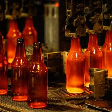 Red hot glass bottles being manufacturered