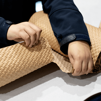 Two hands are tearing Visy Paper Bubble wrap